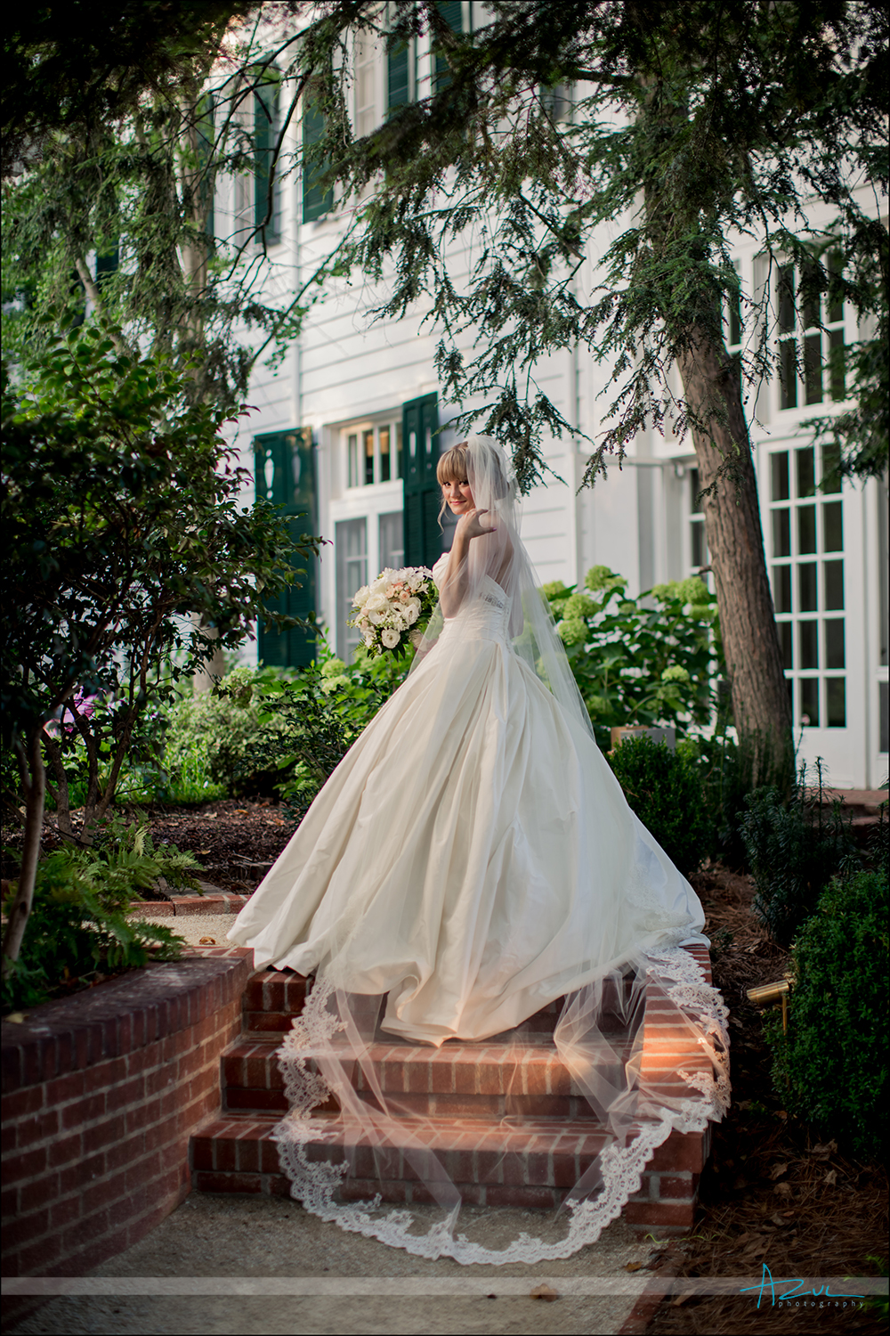 Elegant portrait of bride and veil in courtyard NC