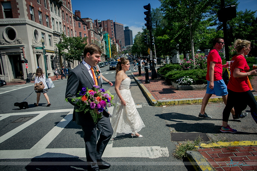 The bride and groom walk to the next portrait location while in Boston Mass