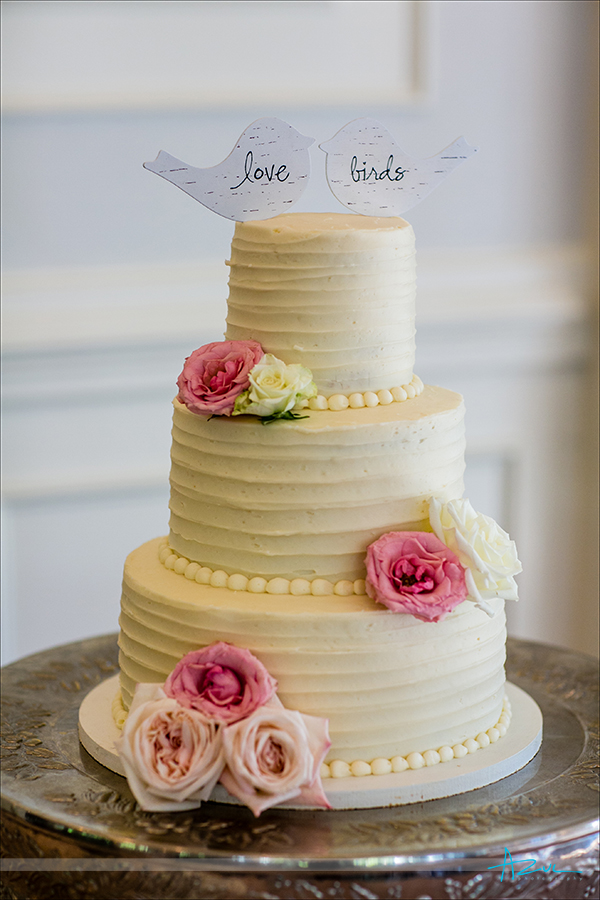 Delicious cake from Sweet Memories is topped with love birds while at the reception at Highgrove Estate in Fuquay Varina, NC.