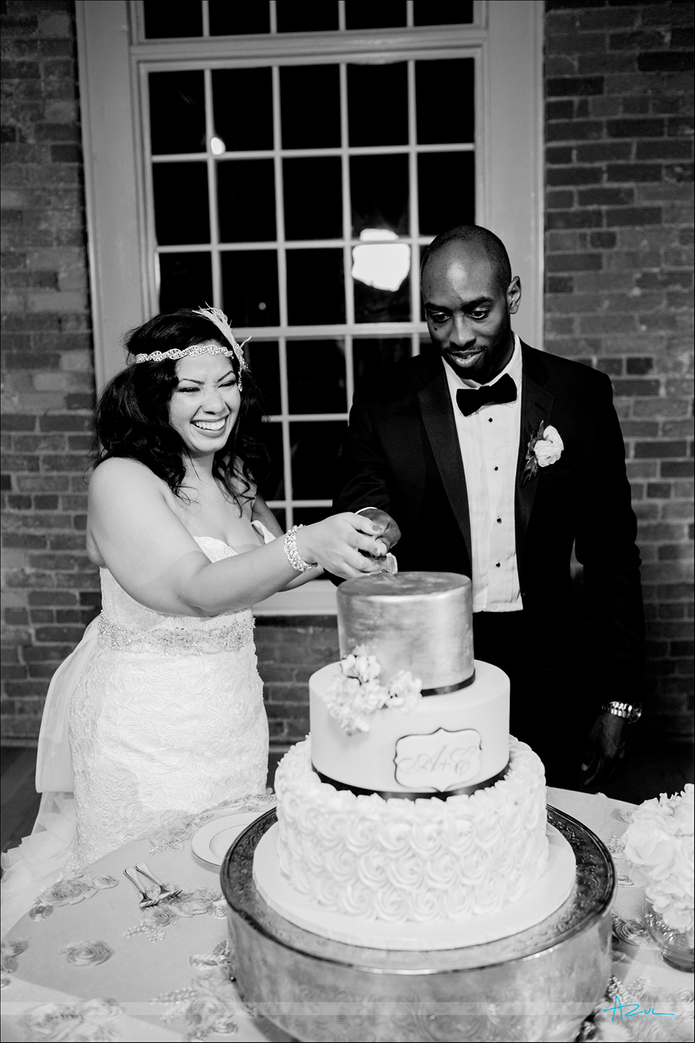 Cutting th cake can be a fun and it was at this wedding at The Cotton Room in Durham located just outside of Raleigh